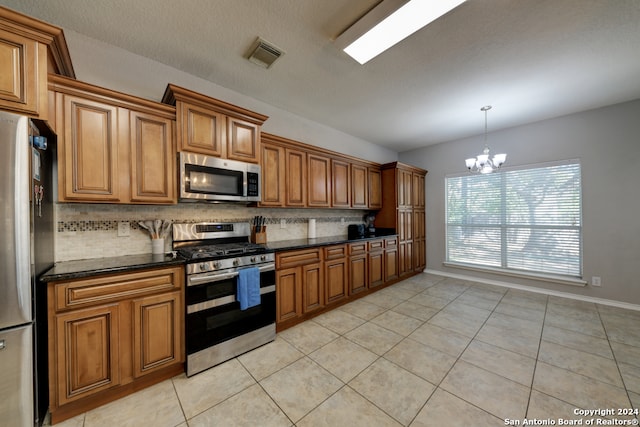 kitchen with light tile patterned flooring, hanging light fixtures, stainless steel appliances, a notable chandelier, and decorative backsplash