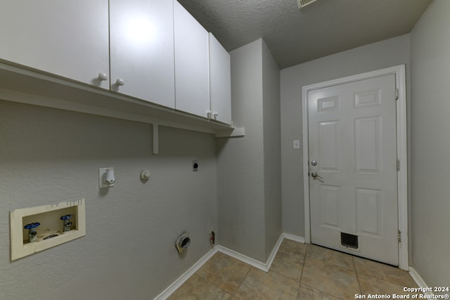 laundry area featuring hookup for a gas dryer, hookup for a washing machine, hookup for an electric dryer, cabinets, and a textured ceiling