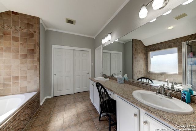 bathroom featuring vanity, a relaxing tiled tub, tile patterned floors, and crown molding