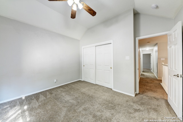 unfurnished bedroom with light carpet, a closet, ceiling fan, and vaulted ceiling