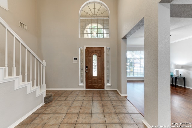 entryway featuring a textured ceiling, wood-type flooring, and a high ceiling