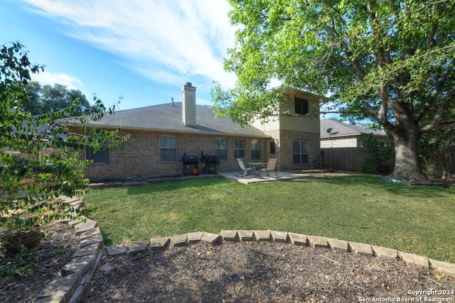 back of house with a patio and a lawn