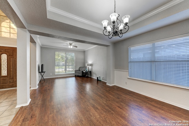 interior space featuring ceiling fan with notable chandelier, crown molding, a textured ceiling, and dark hardwood / wood-style floors