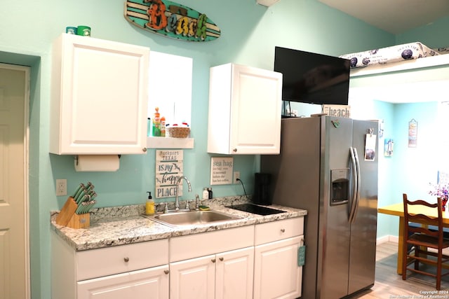 kitchen with white cabinetry, sink, and stainless steel fridge with ice dispenser