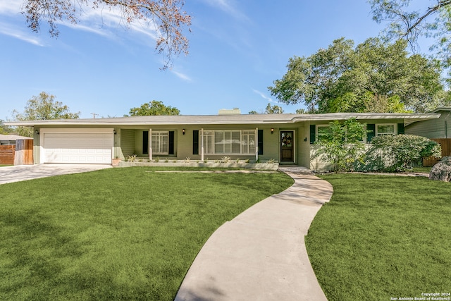 ranch-style home featuring a front lawn, covered porch, and a garage