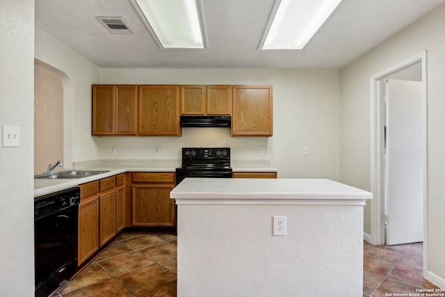 kitchen featuring dark tile patterned floors, black appliances, and sink