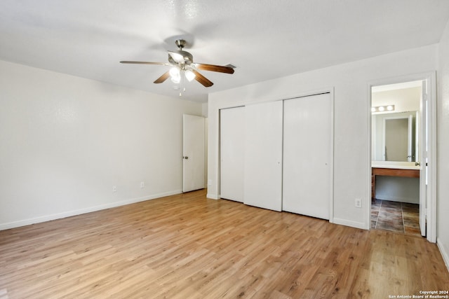 unfurnished bedroom featuring light hardwood / wood-style flooring, ensuite bathroom, and ceiling fan