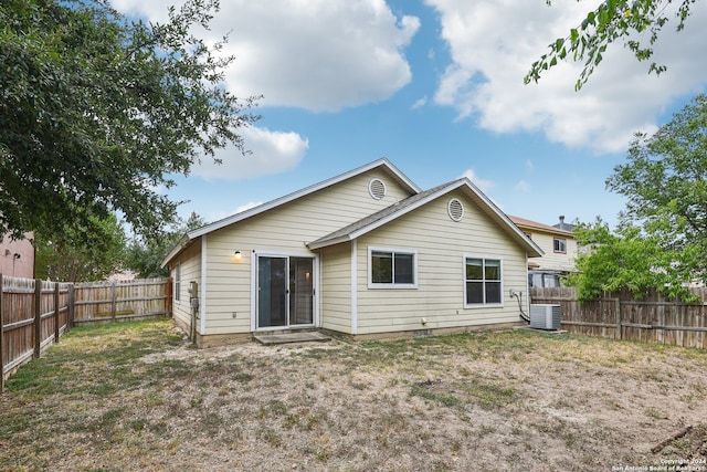 rear view of property with a yard and central AC