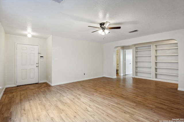 empty room with light hardwood / wood-style flooring, a textured ceiling, and ceiling fan