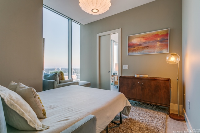 bedroom featuring expansive windows and hardwood / wood-style floors