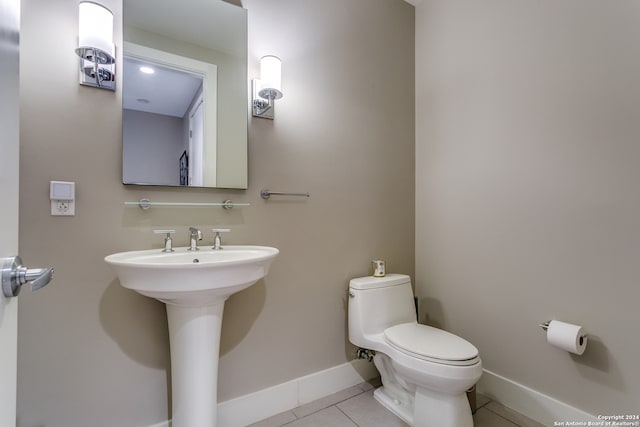 bathroom featuring toilet, tile patterned flooring, and sink