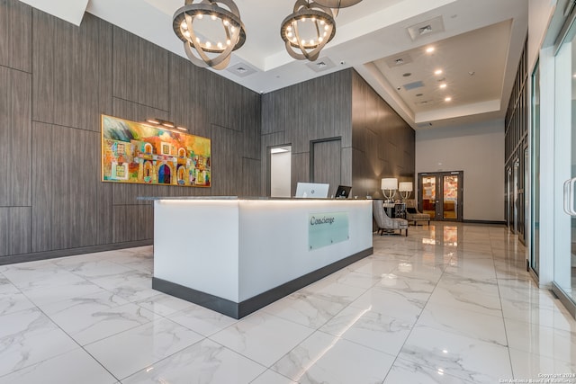 welcome area with french doors and an inviting chandelier