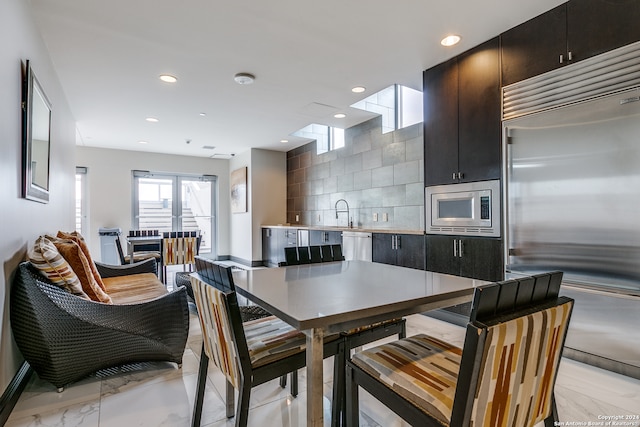 kitchen with sink, tasteful backsplash, and built in appliances