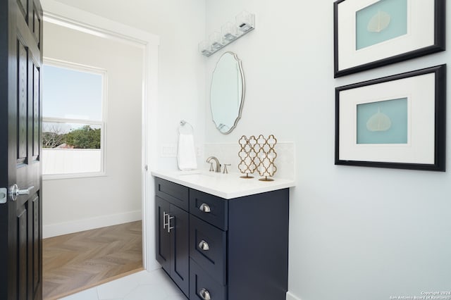 bathroom featuring vanity, decorative backsplash, and parquet flooring