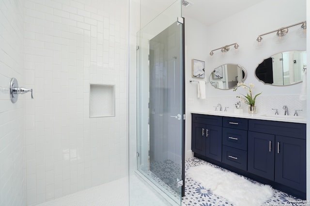 bathroom with vanity, a tile shower, and tile patterned flooring