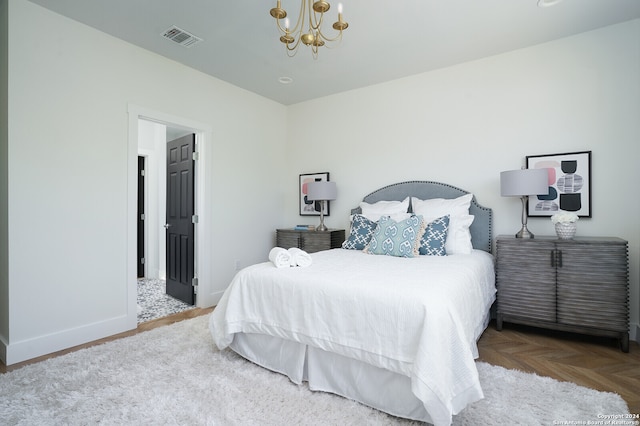 bedroom with parquet flooring and a notable chandelier