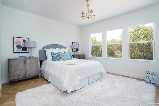 bedroom featuring parquet flooring and an inviting chandelier