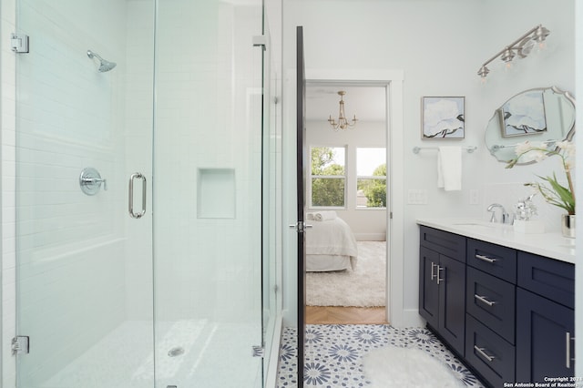 bathroom with vanity, a notable chandelier, tile patterned flooring, and an enclosed shower