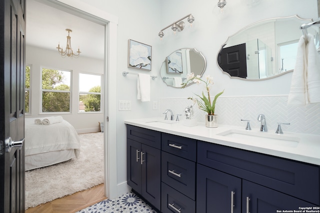 bathroom featuring vanity, backsplash, a shower, and a chandelier