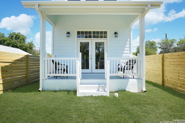 back of property with french doors and a lawn