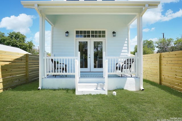 244 Porter St, San Antonio, TX 78210 - view of exterior entry with fence, french doors, and a lawn