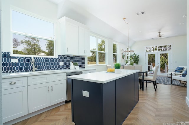 244 Porter St, San Antonio, TX 78210 - kitchen featuring light countertops, a center island, a healthy amount of sunlight, white cabinetry, and dishwasher