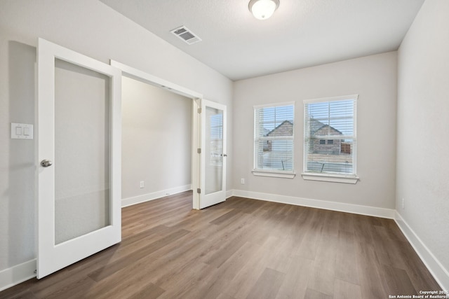 1327 Larkspur Pass, San Antonio, TX 78245 - unfurnished bedroom featuring wood-type flooring and french doors