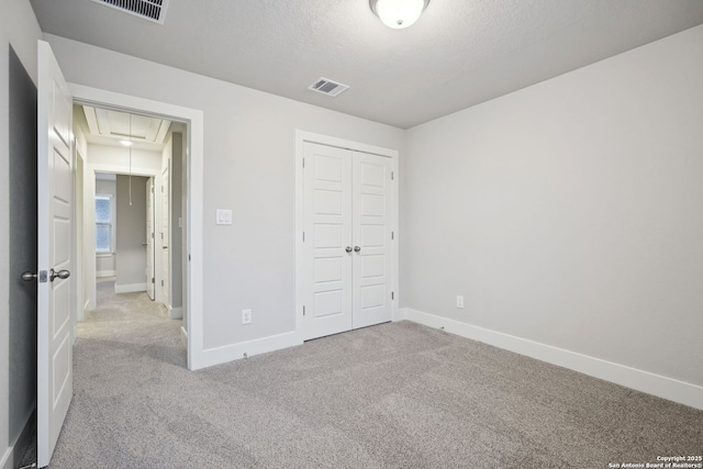 1327 Larkspur Pass, San Antonio, TX 78245 - unfurnished bedroom featuring light colored carpet, a textured ceiling, and a closet
