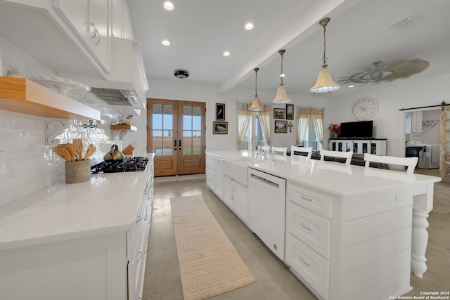 kitchen with white cabinets, a spacious island, a barn door, white dishwasher, and french doors