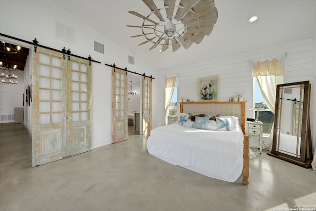 unfurnished bedroom featuring ceiling fan, vaulted ceiling, and a barn door