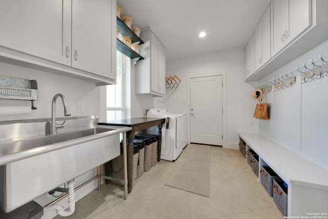 clothes washing area featuring cabinets and separate washer and dryer