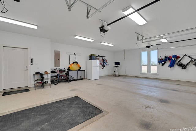 garage with electric panel, a garage door opener, and white fridge