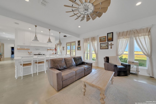 living room featuring ceiling fan and a wealth of natural light