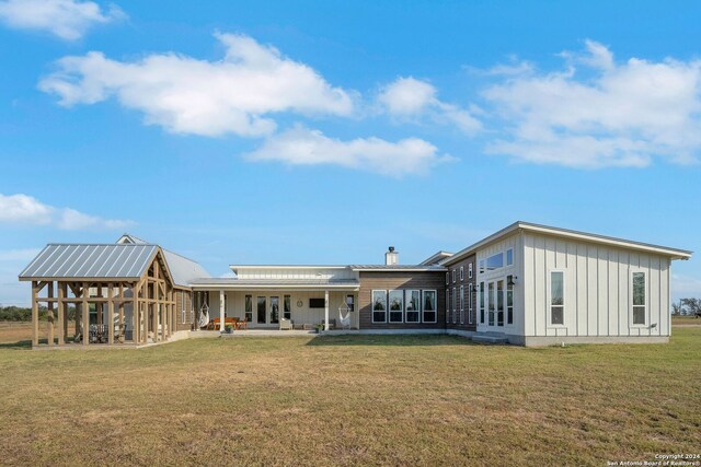 back of house with a yard and a patio