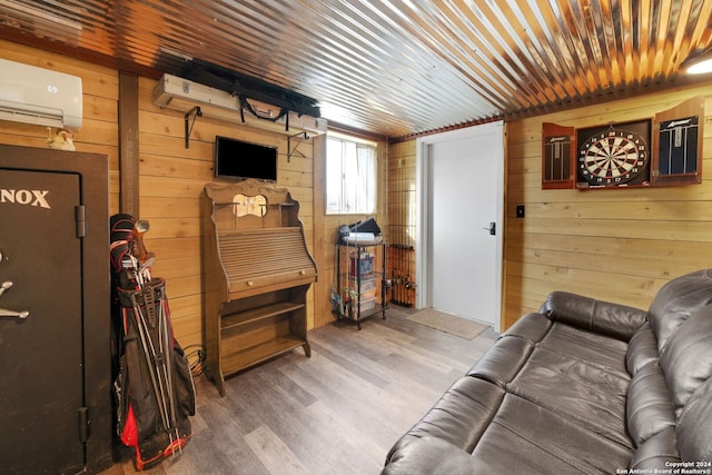 living room featuring an AC wall unit, wooden walls, and hardwood / wood-style flooring