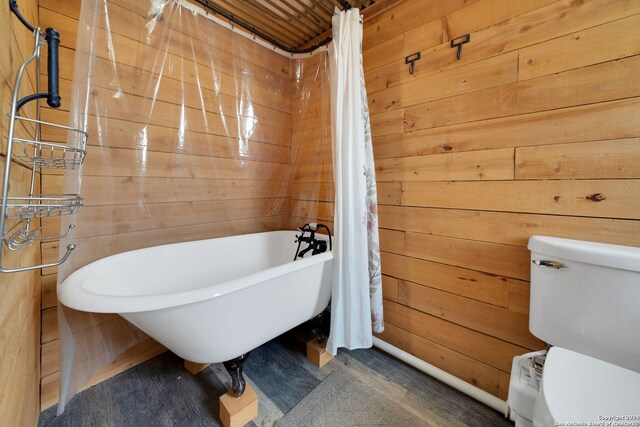 bathroom featuring wooden walls and toilet