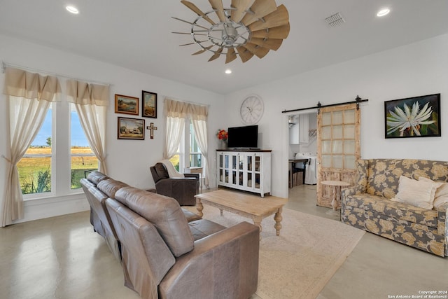 living room featuring ceiling fan, a wealth of natural light, and a barn door