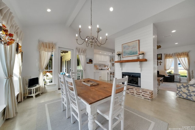 dining area with vaulted ceiling with beams, an inviting chandelier, and a brick fireplace