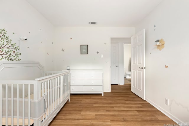 unfurnished bedroom featuring light wood-type flooring and a crib