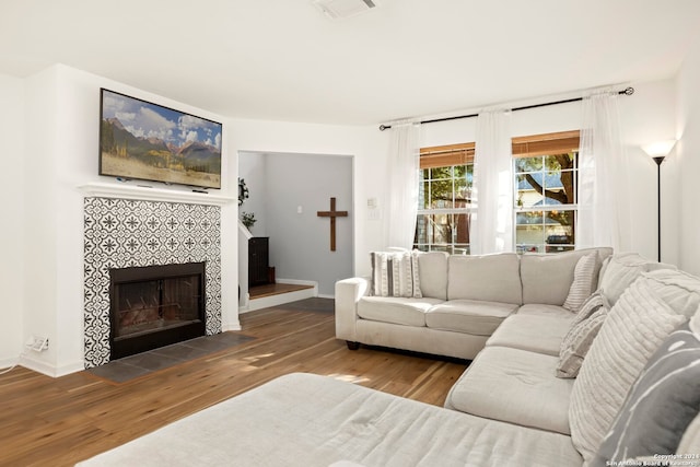 living room featuring hardwood / wood-style floors and a tiled fireplace