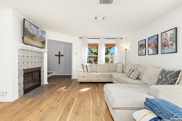 living room featuring wood-type flooring and a fireplace