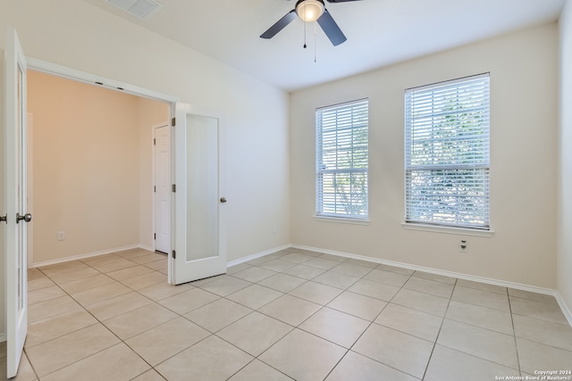 tiled spare room with ceiling fan