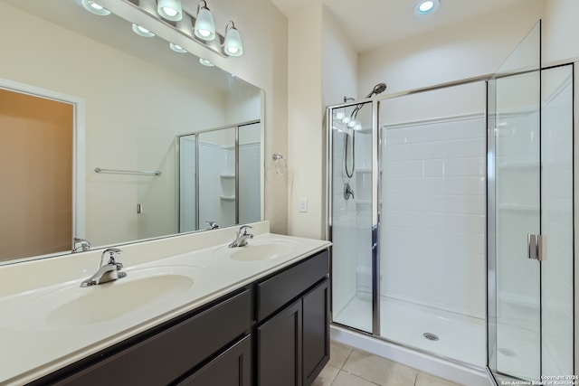 bathroom featuring a shower with door, tile patterned flooring, and vanity