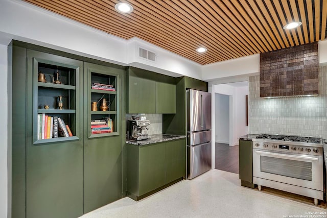 kitchen featuring stainless steel appliances, backsplash, green cabinetry, stone counters, and built in features