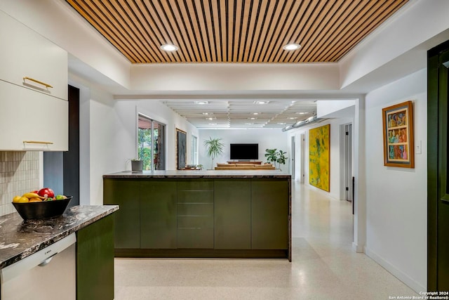 kitchen featuring white cabinetry, dark stone countertops, green cabinetry, a tray ceiling, and stainless steel dishwasher