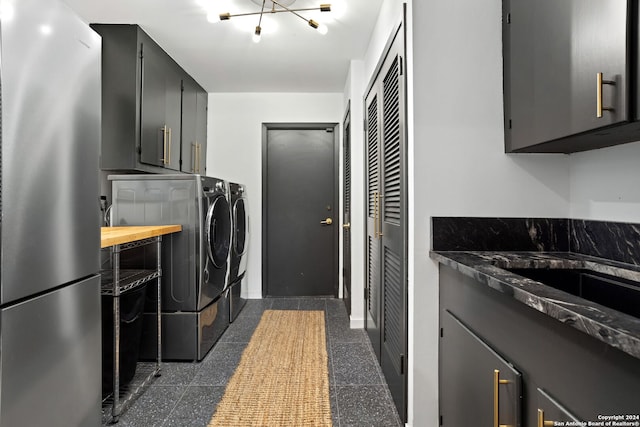 laundry room with washing machine and dryer, cabinets, and a chandelier