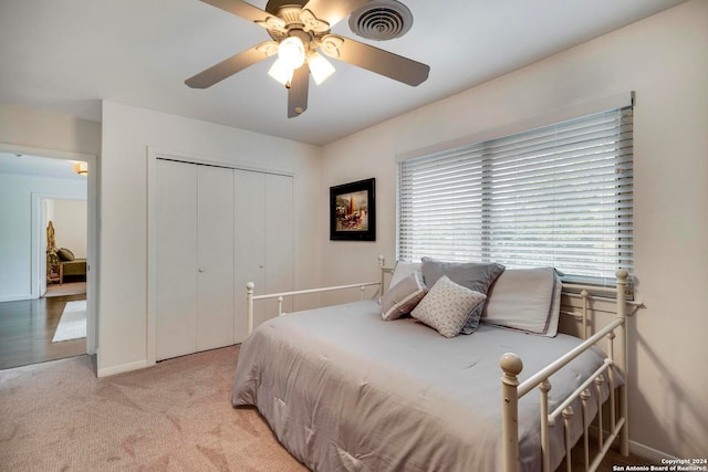 bedroom featuring a closet, light carpet, and ceiling fan