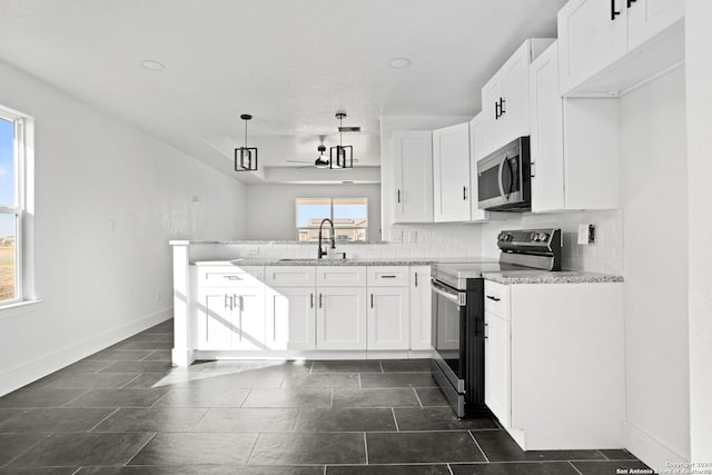 kitchen featuring white cabinetry, light stone counters, stainless steel appliances, and sink