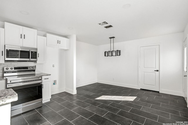 kitchen with light stone counters, white cabinets, stainless steel appliances, and decorative light fixtures