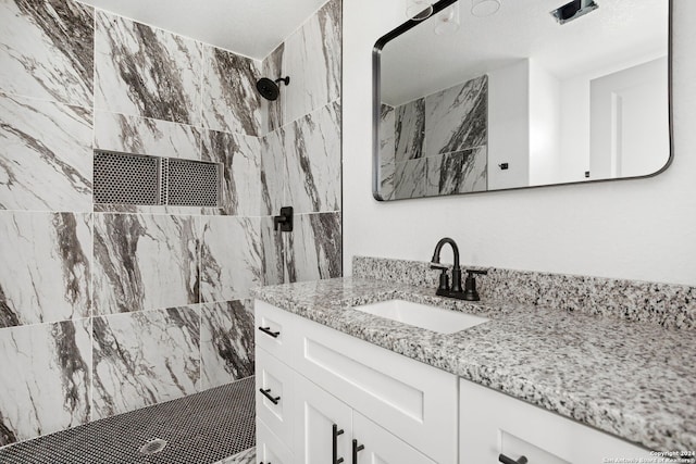 bathroom with vanity and tiled shower